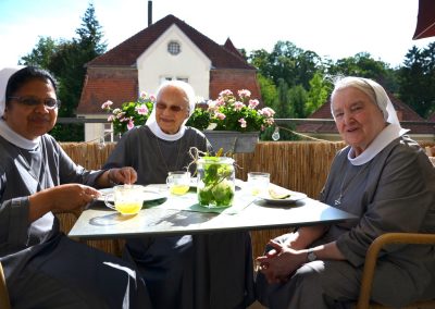 3 Schwestern sitzen fröhlich auf dem Balkon
