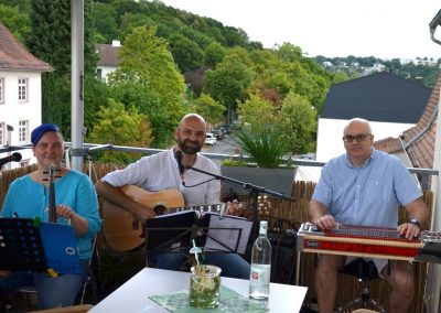 3 Musiker spielen auf dem Balkon