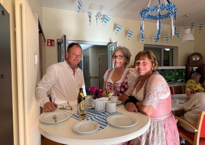 Am Stehtisch drei Personen bayerisch gekleidet